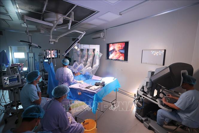 Ê kíp y bác sĩ bệnh viện K thực hiện phẫu thuật nội soi Robot cho bệnh nhân ung thư buồng trứng. (Ảnh: Minh Quyết/TTXVN)